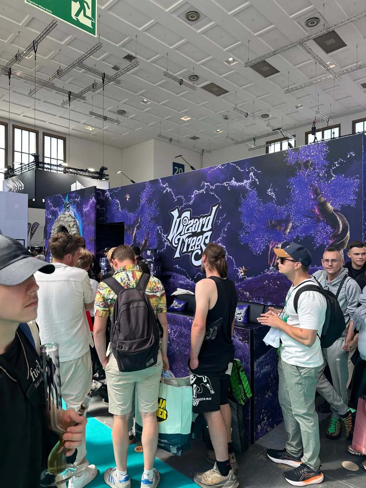 Stánek Wizard Trees s fialovým brandingem a návštěvníky na Mary Jane Berlin 2026